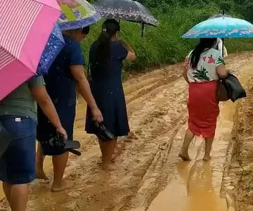 Mulheres da Assembleia de Deus em Pernambuco caminhando na lama para o círculo de oração, expressando fé e devoção em meio a adversidades