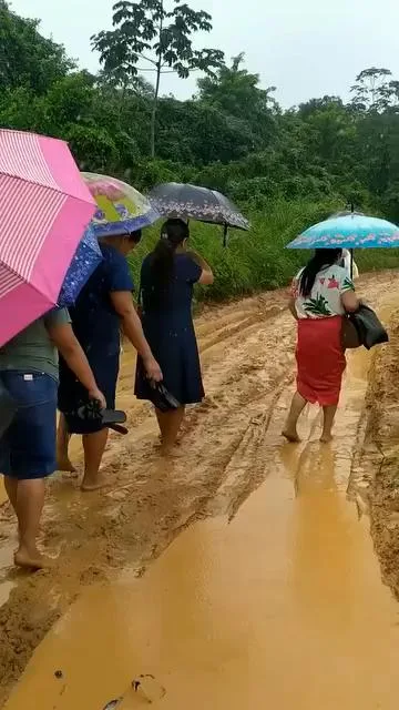 Mulheres da Assembleia de Deus em Pernambuco caminhando na lama para o círculo de oração, expressando fé e devoção em meio a adversidades